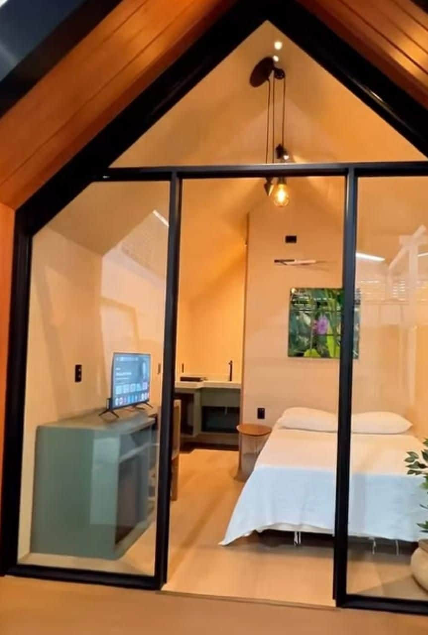 A bedroom with a bed, bedside table, and a desk with a computer.