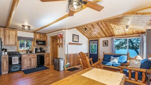 Una cocina amplia con armarios de madera, un comedor con mesa de madera y una zona de estar acogedora con vistas al exterior.