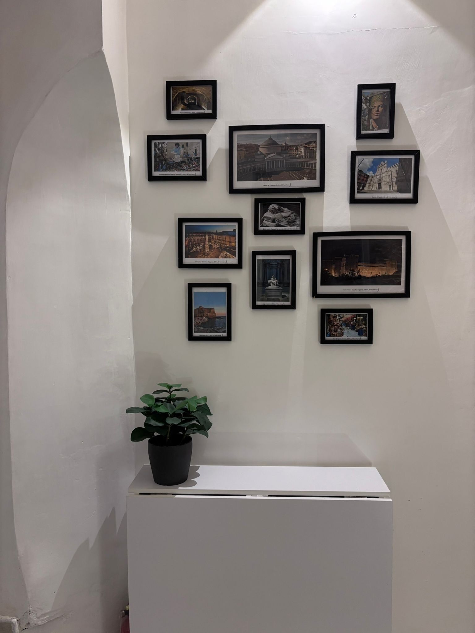 A wall with multiple framed pictures of various buildings and landmarks.