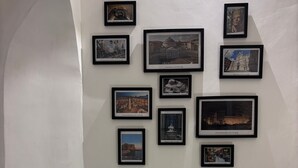 Eine Wand mit mehreren gerahmten Bildern verschiedener Gebäude und Sehenswürdigkeiten.