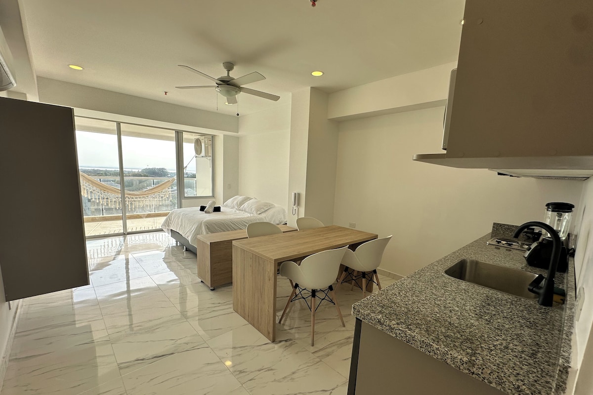 Quarto moderno com cama, mesas de cabeceira e uma janela grande.