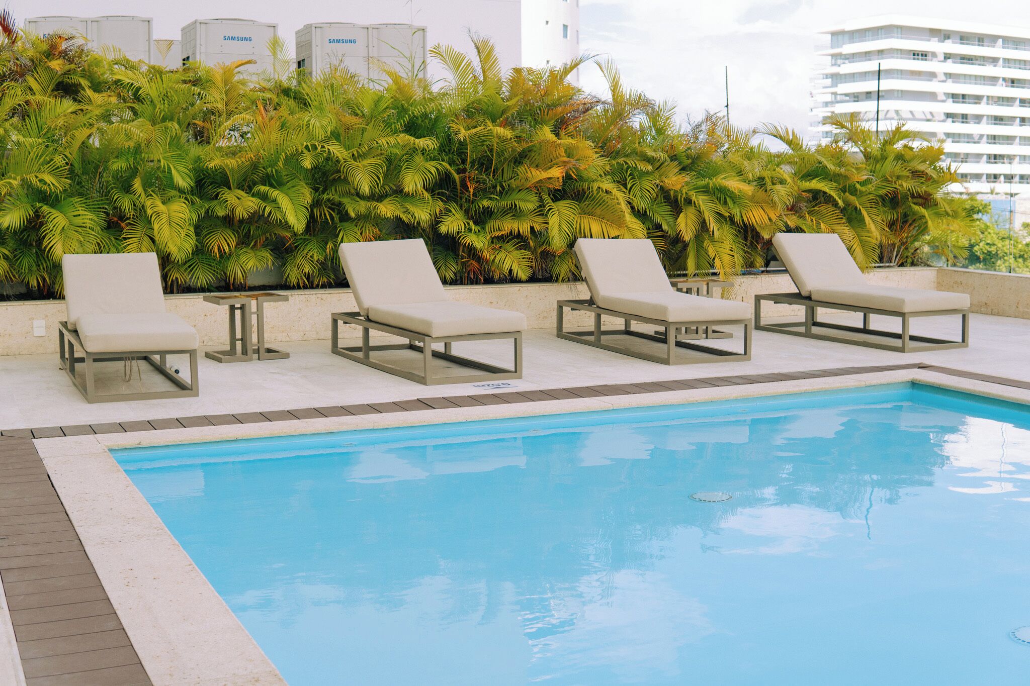 Un área junto a la piscina con sillones de descanso.