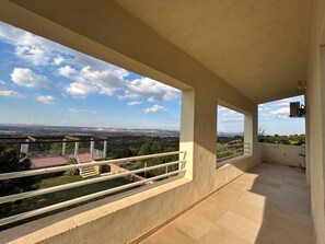 A balcony with a view of a distant landscape, including a sports field and greenery. - Dar Nesri (Zaghouan)
