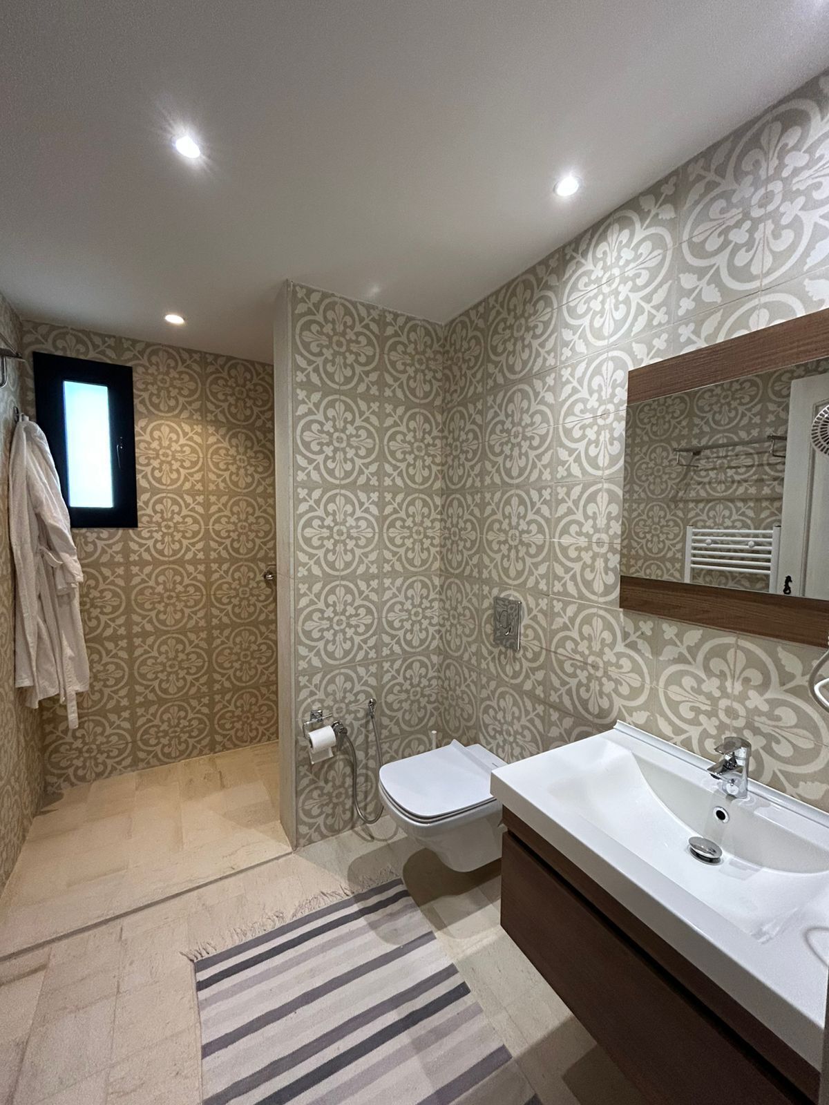 Een badkamer met douche, toilet en wastafel.