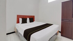 Une chambre d’hôtel avec un lit, une armoire et une petite fenêtre.