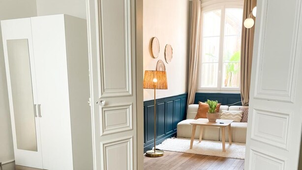 Een hotelkamer met een bed, een kledingkast, een zithoek met een tafel en stoelen, en uitzicht op de omgeving.