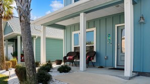 A two-story building with a covered porch, outdoor seating, and a decorative seahorse. - Sealavie (Port St. Joe)