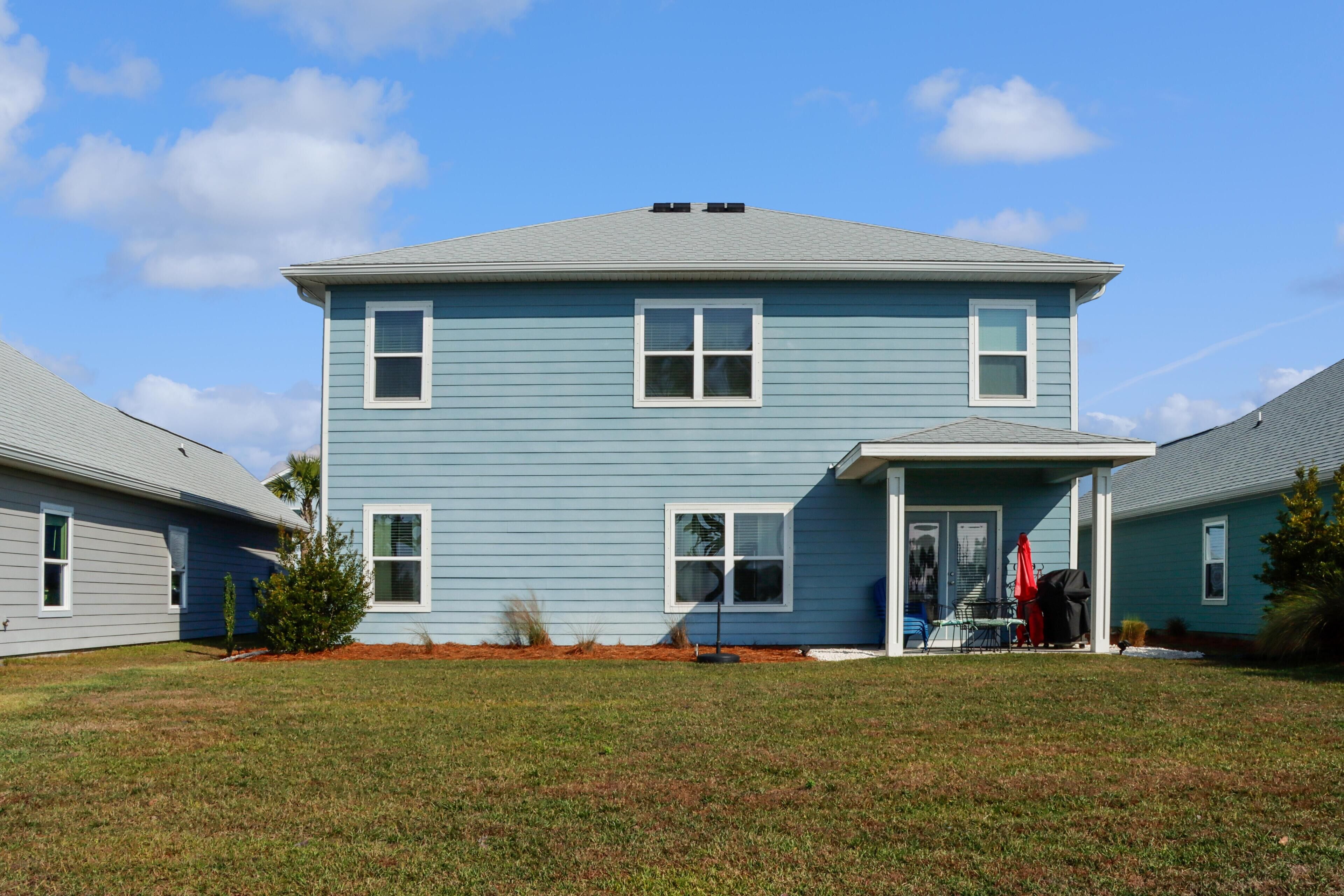A two-story house with a front porch, a covered entryway, and a small front yard.