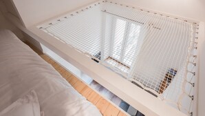 A room with a bed, a white netted window, and a wooden floor. - SmartStay Perrache - Presqu'île (Lyon)