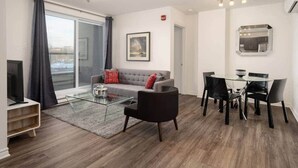 Una sala moderna con sofá, mesa de centro y comedor.