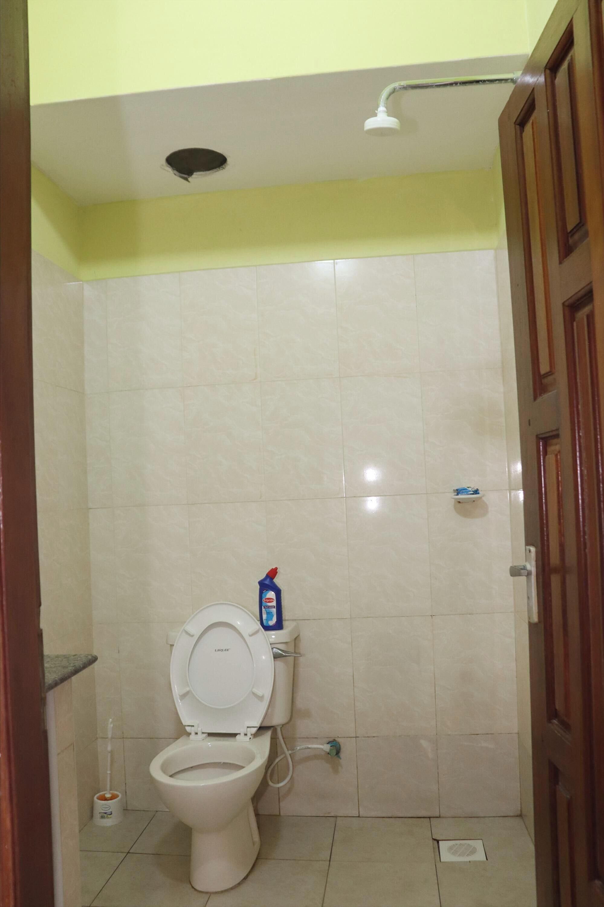 A small, clean bathroom with a toilet, a shower, and a sink.