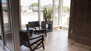 Ein moderner Sitzbereich mit Kamin, großen Fenstern und Blick auf die Straße.