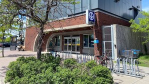 A METRO station with a brick facade, a covered entrance, and a bike parking area.