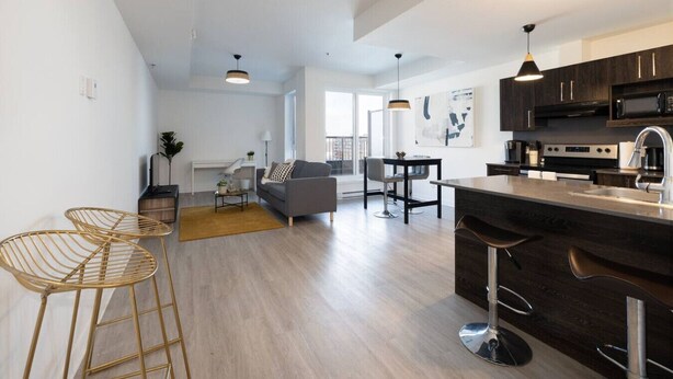 A modern apartment with a kitchen, dining area, and living room. - Buchanan *609* - Midtown Luxe Loft + gym (Montreal)