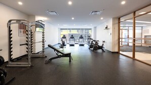 A gym with weightlifting equipment, treadmills, and stationary bikes. - Buchanan *705* - Midtown Luxe Loft + gym (Montréal)