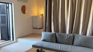 Ein modernes Wohnzimmer mit einer Couch, einem Couchtisch und einer Wand-Klimaanlage.