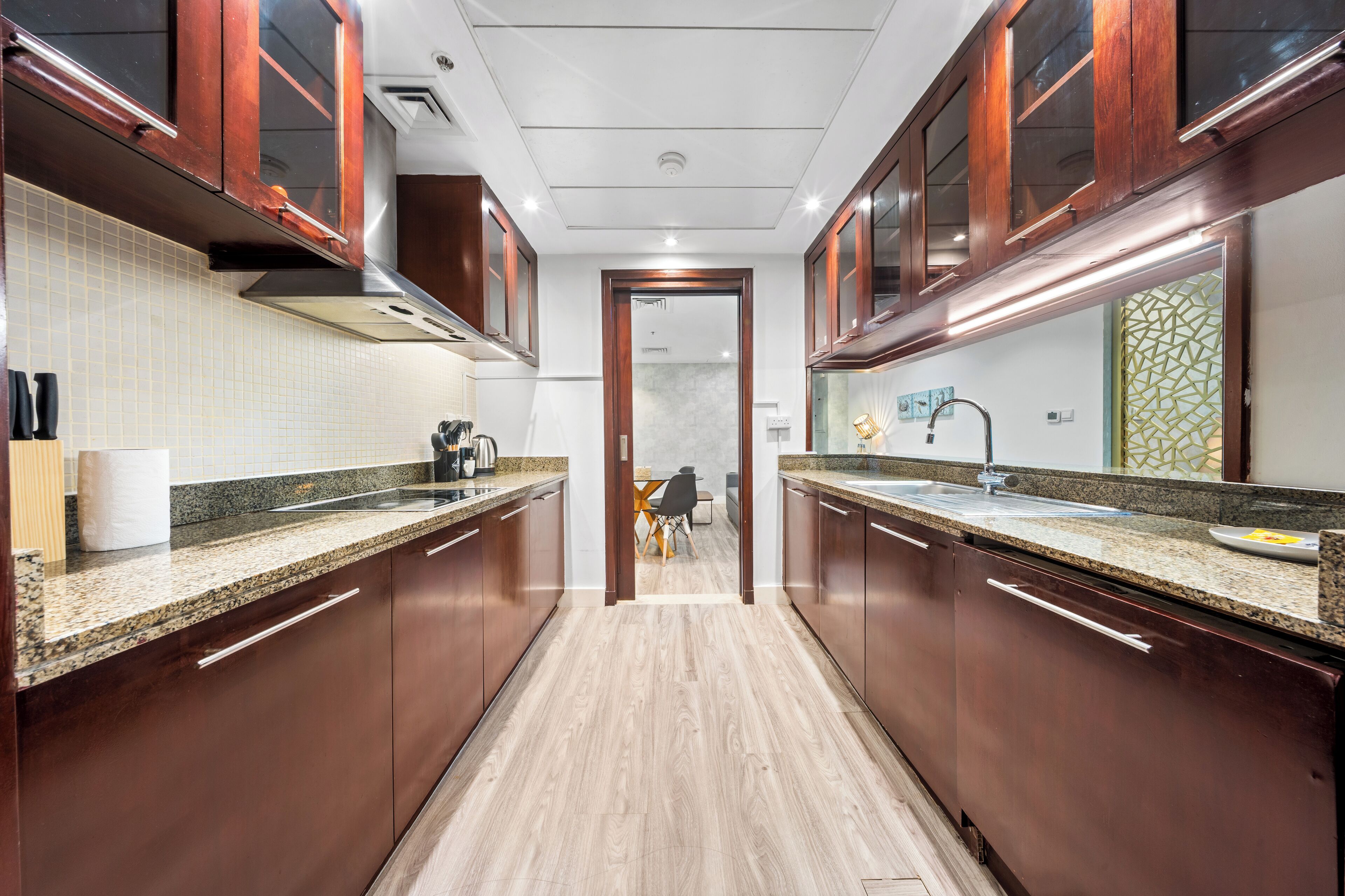 Een moderne keuken met granieten aanrechtbladen, houten kastjes en een centraal eiland.
