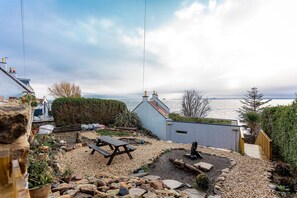 A coastal property with a patio area, a wooden deck, and a view of the sea. - The Deck House | St Monans (St Monans)