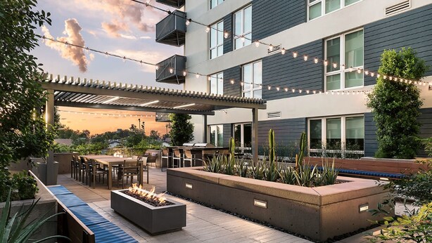 An outdoor patio area with a fire pit, seating, and string lights. - Landing | Stylish 2BD, Yoga Studio, Clubhouse (Tempe)