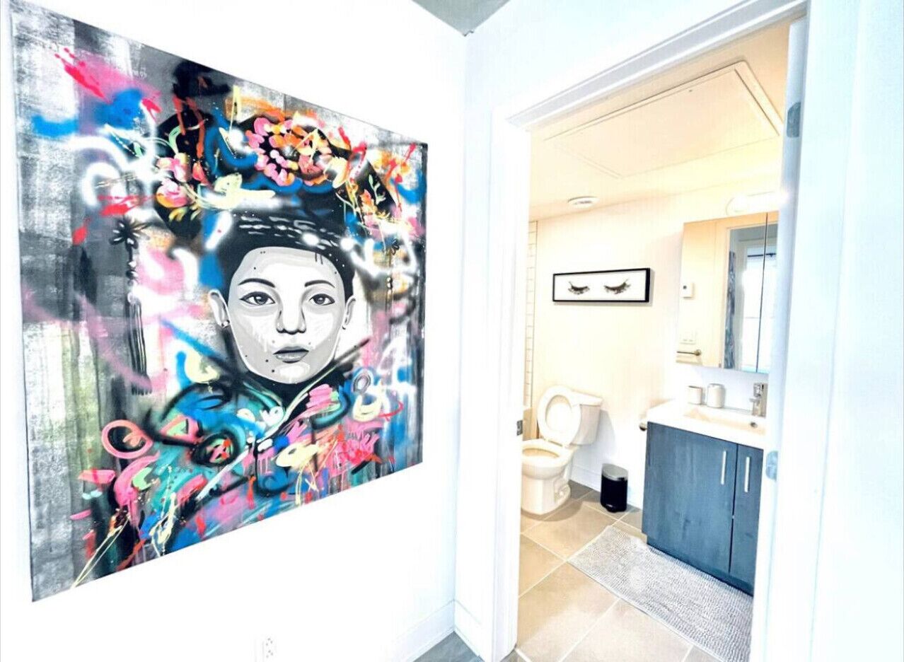 A modern bathroom with a toilet, sink, and cabinet.