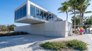 A modern building with a large glass facade and the name "SIESTA BEACH" on the ground. - Beechwood  Suites  D (Sarasota)