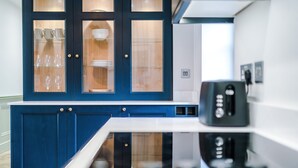 Una cocina moderna con armarios azules, una encimera blanca y un horno empotrado.