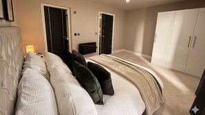 Ein Schlafzimmer mit einem Bett, zwei Türen, einem Kleiderschrank und einem Nachttisch mit Lampe.