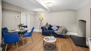 Een moderne woonkamer met een eethoek, een bank en een salontafel.