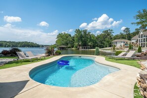 A swimming pool with lounge chairs, a dock, and a view of a lake. - Oasis @ Bayshore - Lakefront Luxury 6BR w Stunning Views, Private Pool, Hot Tub (Hot Springs)