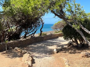 A rocky path leading to a coastal area with trees and a clear view of the sea. - Apartment 'Casa De Stefan' with Balcony (Cascais)