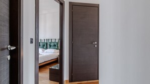 A bedroom with a bed, a dark wooden door, and a mirror reflecting the room. - GuestHost - Spacious and bright apartment of approximately 80 square meters, perfect for four people, located on the fifth floor of a building (NO elevator).The property is located in a quiet area and well-connected to the center of Turin by surface tran (Turin)