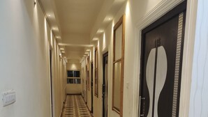 A long, narrow hallway with patterned flooring and doors on both sides.