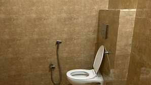 A bathroom with a toilet, a shower, and a sink.