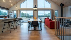 A spacious kitchen with a large island, bar stools, and a dining area with a table and chairs.