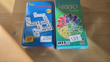 Zwei Brettspiele, Domino und Skyjo, auf einem Holztisch.