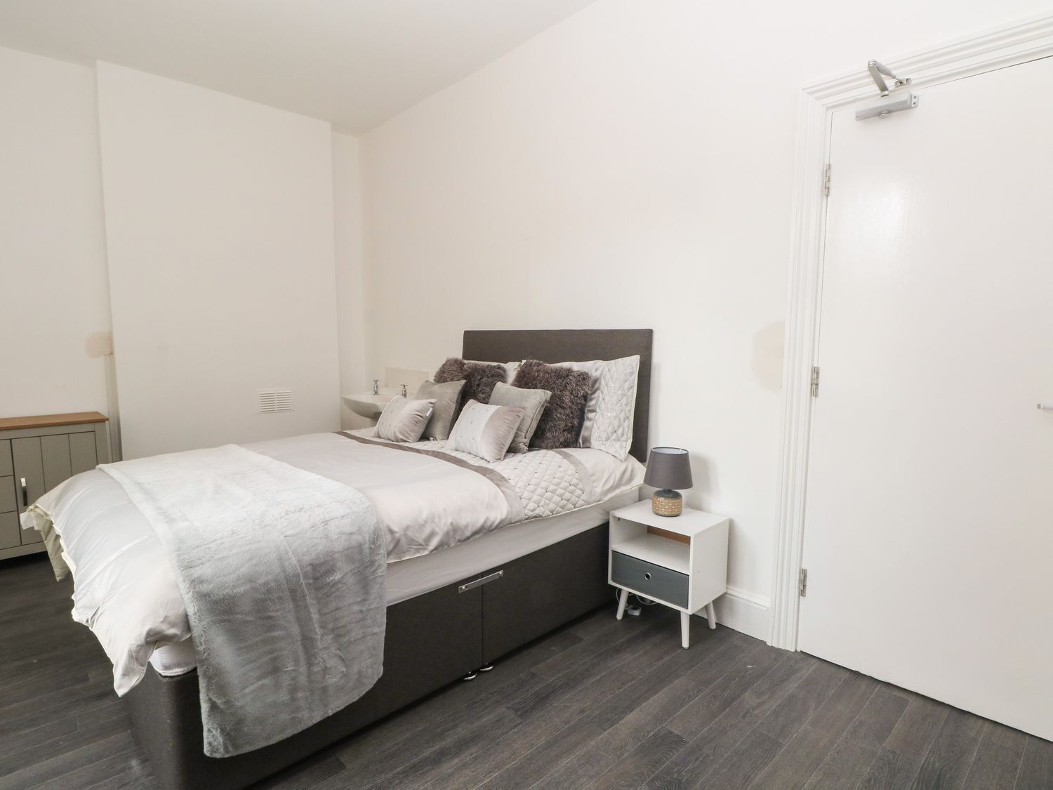Une chambre à coucher avec un lit, une table de chevet et une armoire.