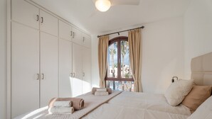A bedroom with a large bed, a wardrobe, and a window with curtains. - Vacation Apartment 'Tagoropark Relax' with Shared Pool, Private Terrace and Wi-Fi (Costa del Silencio)