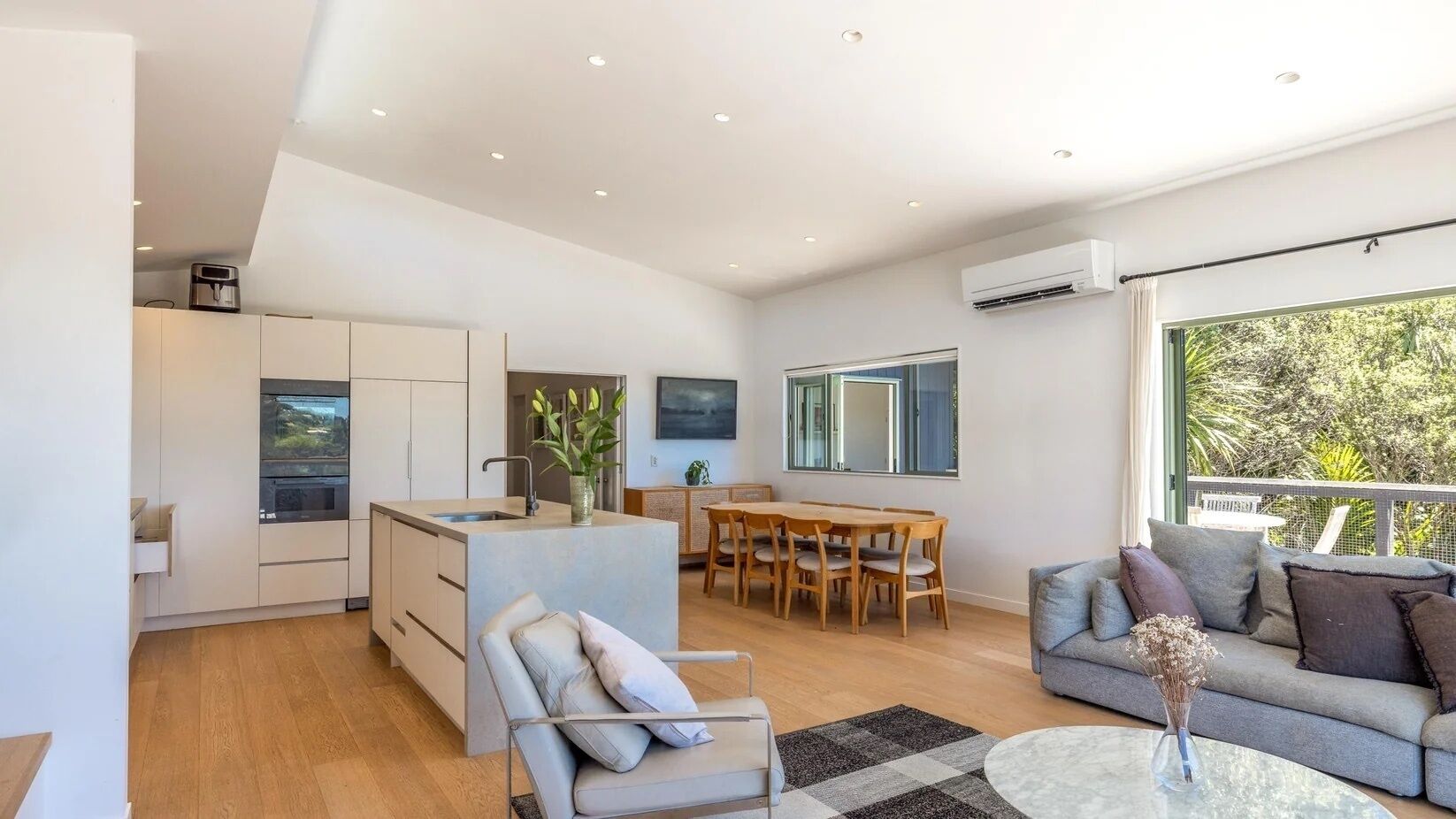 A modern living space with a kitchen, dining area, and seating area.