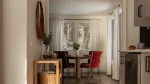 Eine moderne Küche mit Essbereich, Holzboden und Blick ins Freie.