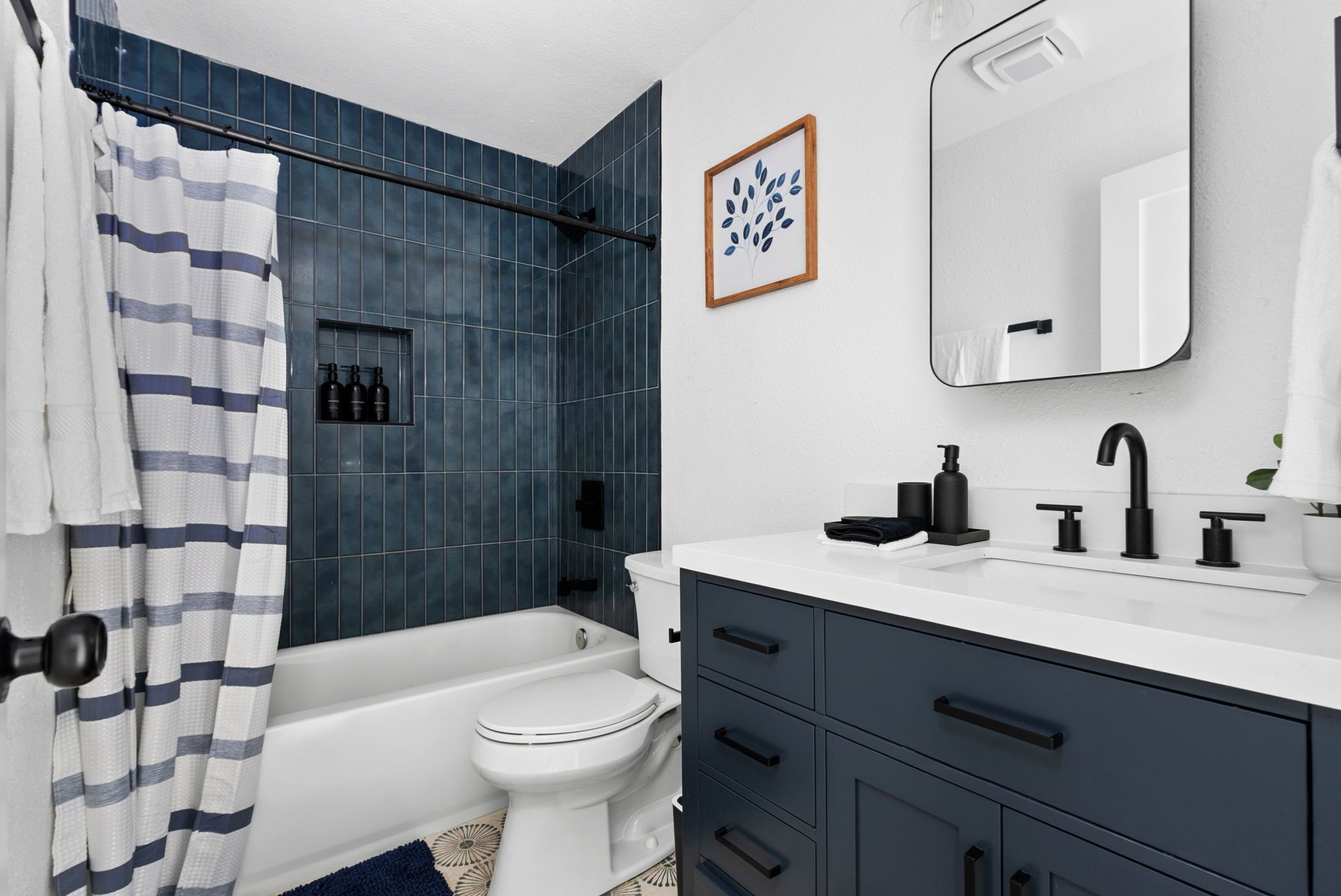 Un bagno moderno con vasca, toilette e mobile lavabo con specchio.