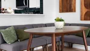 A modern living room with a grey sofa, a round wooden table, and a potted plant. - Southport Combined (Austin)