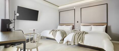 A hotel room with a bed, bedside tables, a desk, and a chair.