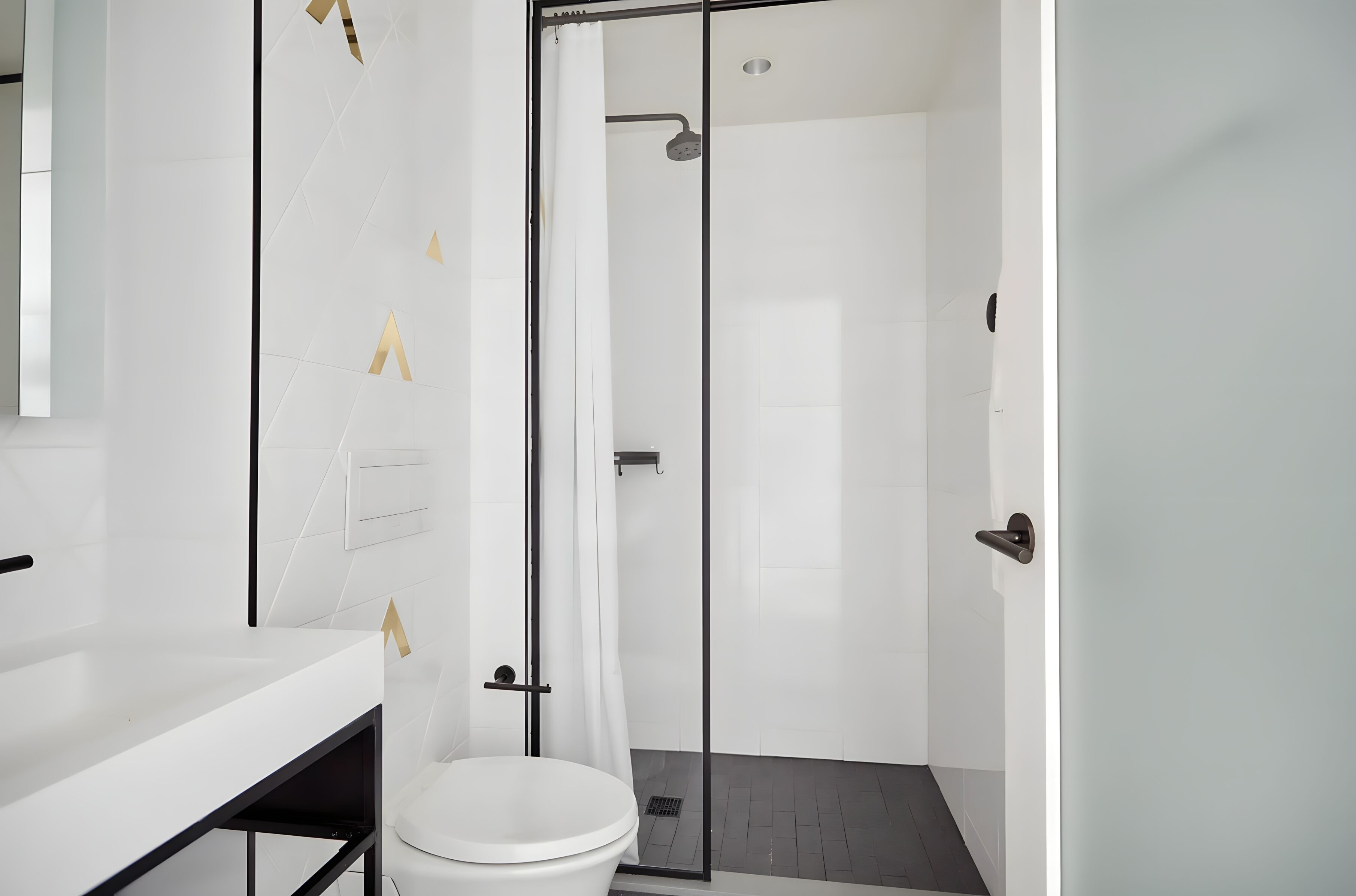 Ein modernes Badezimmer mit Waschbecken, Toilette und Duschbereich, alles in Weiß.