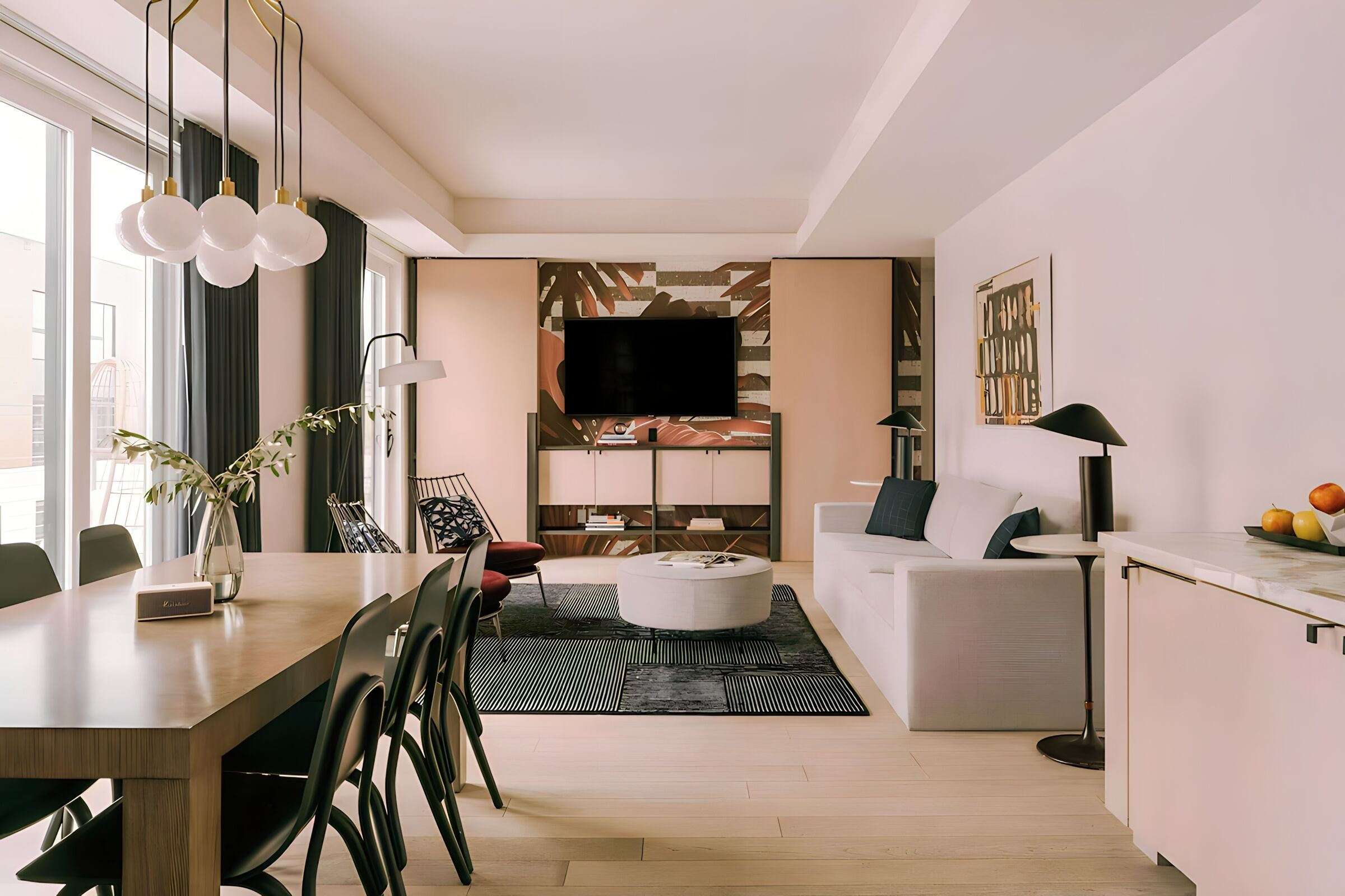 Ein modernes Wohnzimmer mit Flachbildfernseher, rundem Couchtisch und Essbereich mit Holztisch und Stühlen.