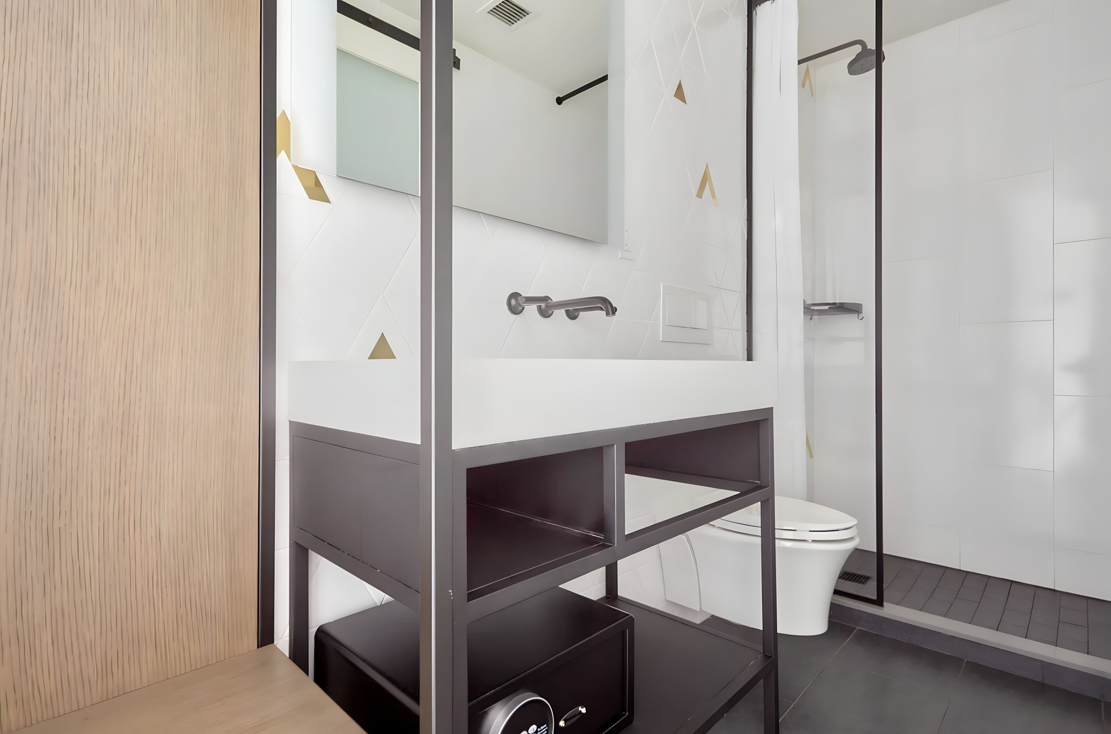 Un baño moderno con lavamanos blanco, inodoro y zona de ducha.