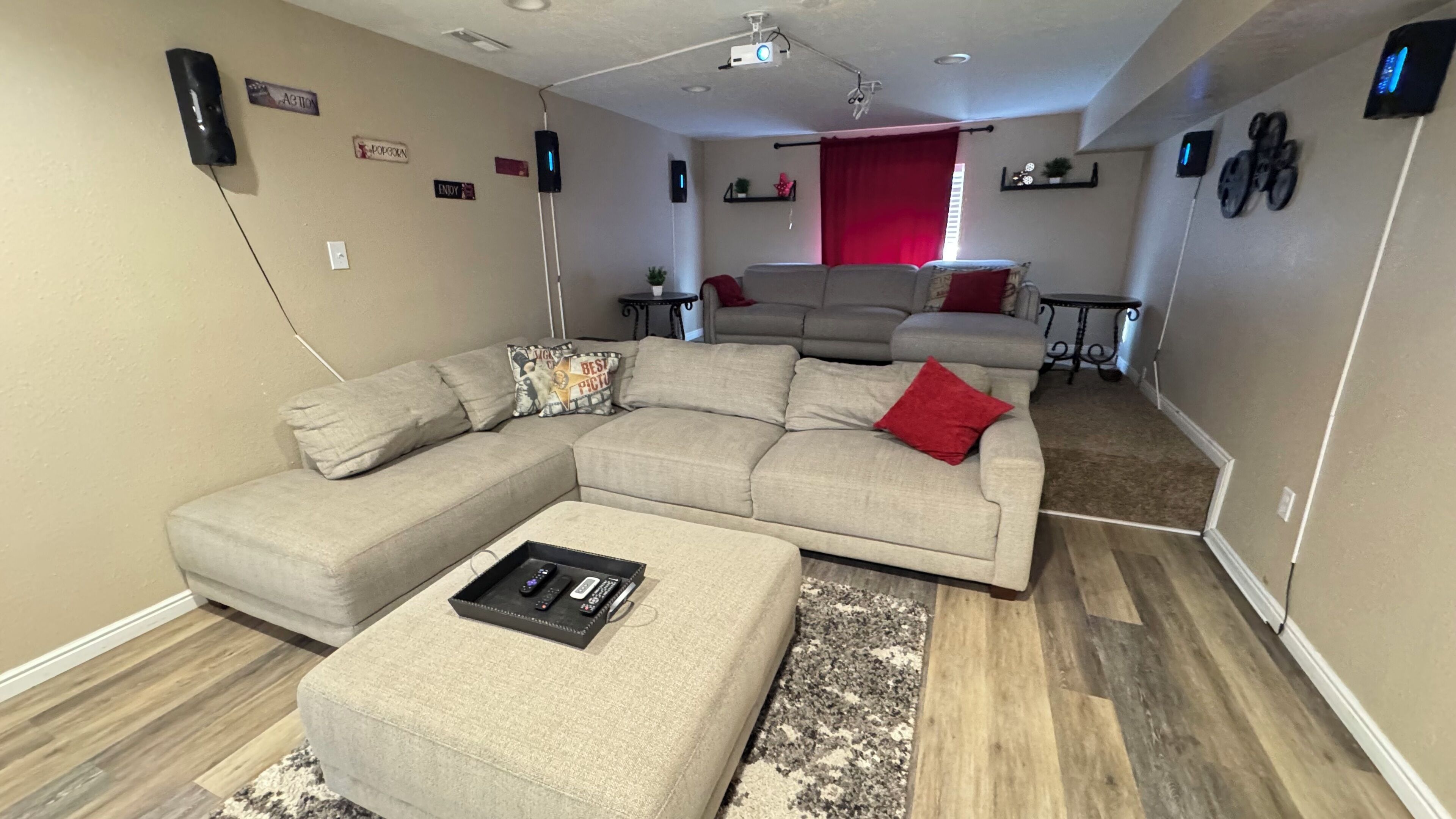 A modern living room with a sectional sofa, ottoman, and a small coffee table.