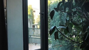 Une pièce dotée d’une grande porte-fenêtre coulissante donnant sur un balcon. Devant la porte, on trouve un petit escalier et un paillasson.