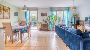 Un'ampia zona giorno con tavolo da pranzo, sedie, divano e televisione.