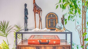 Un tavolo con una statua di un uomo, una giraffa e un mobile decorativo.