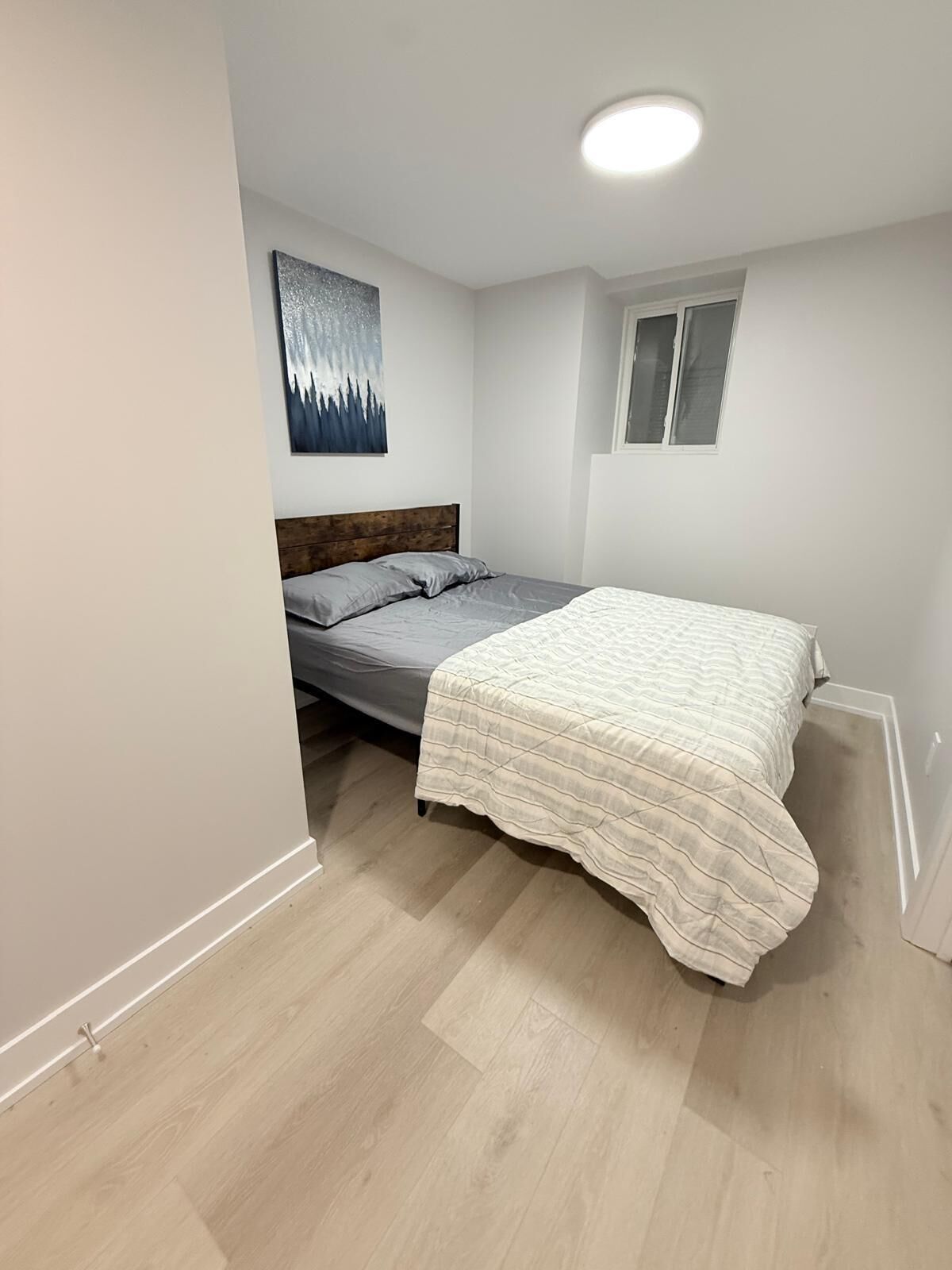 Quarto com uma cama, janela e luminária de teto.